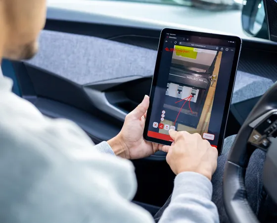 Monteur nutzt ein Tablet, um aus der Ferne mitzuschauen und Bauteile zu markieren.